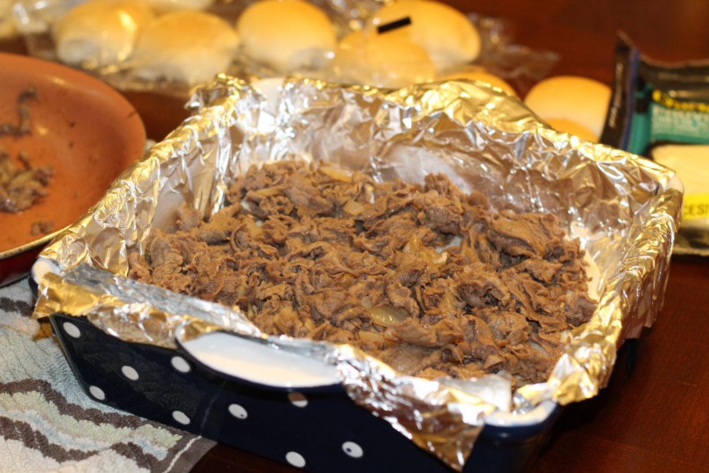 Layering Steak & Cheese Sliders in Baking dish