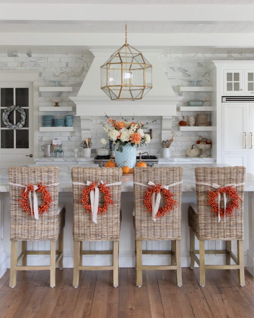 Kitchen island and stools decorated with dried wreath and fall flowers