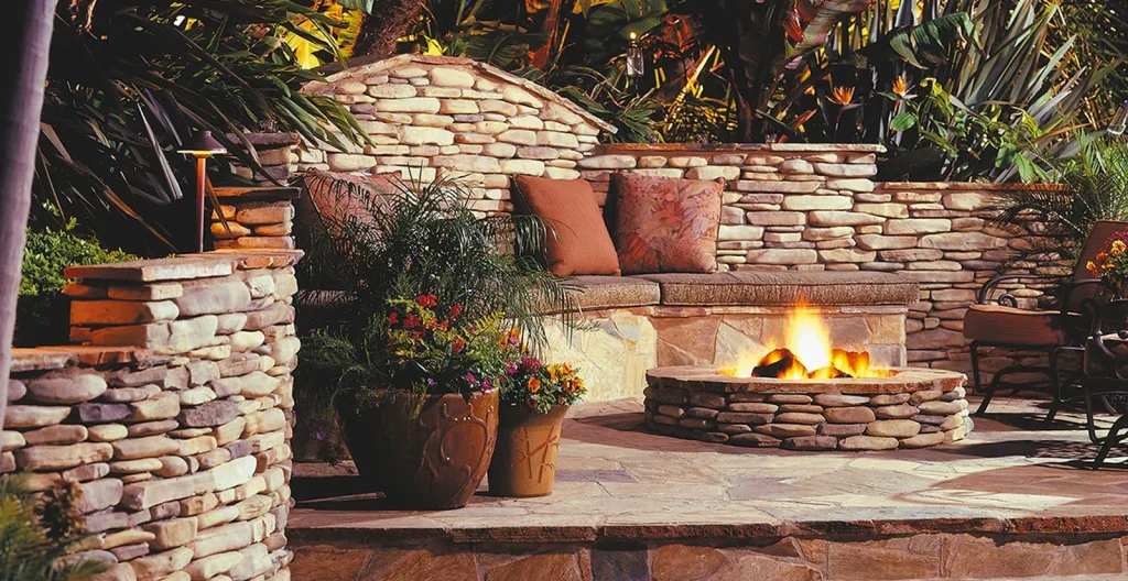 Rustic stone fire pit and stone patio seating hardscaped