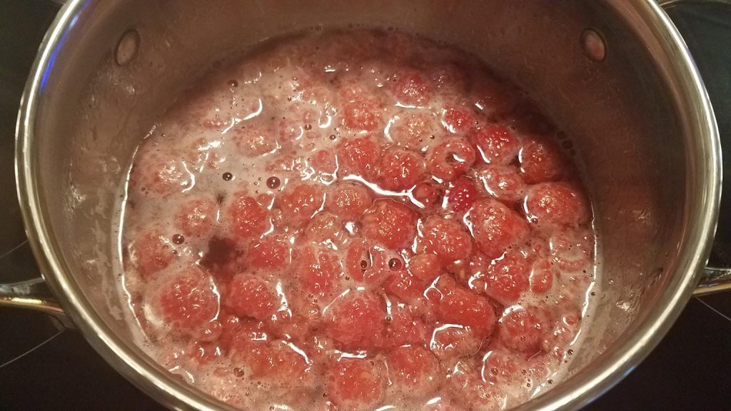 straining the raspberries for raspberry syrup