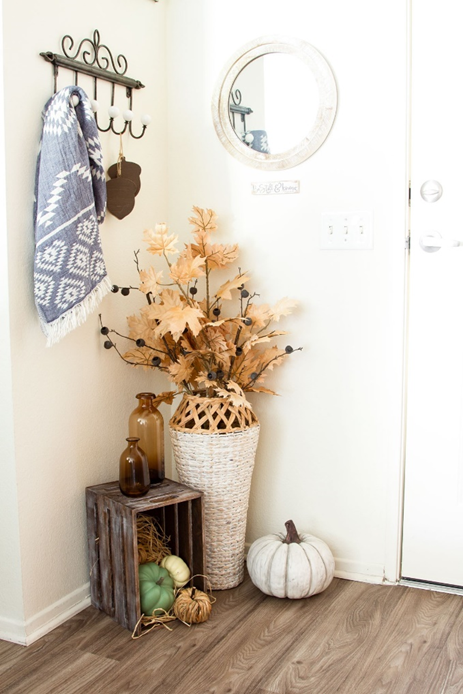 Fall Entryway Vignette with Crate, Tall Vase of Fall Leaves, Brown Glass Bottles and Pumpkins