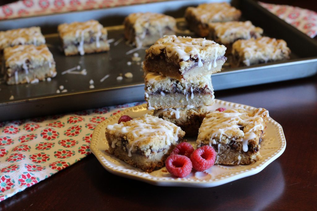 raspberry bars stacked on a dish