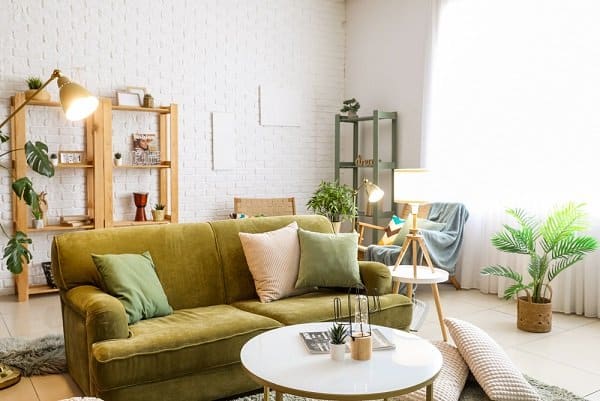 Boho living room with glowing lamps, soft pillows, styled shelves and houseplants