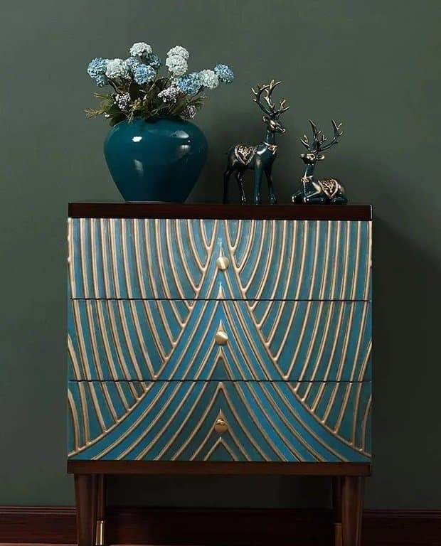 teal dresser with bold gold design and knobs